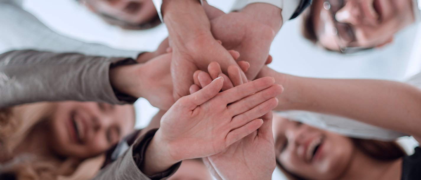 Fidelizzazione del personale Persone sorridenti che mettono le mani insieme in segno di unità