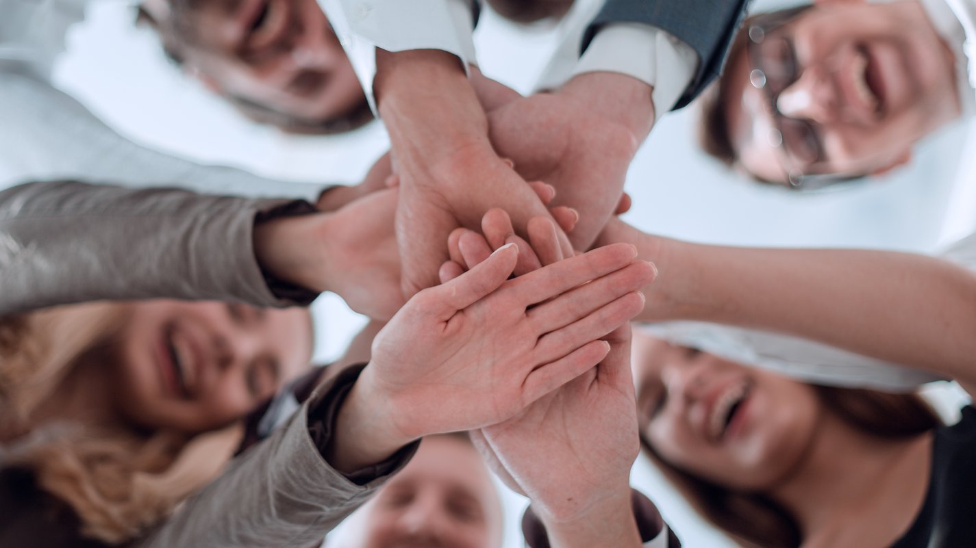 Fidelizzazione del personale Persone sorridenti che mettono le mani insieme in segno di unità