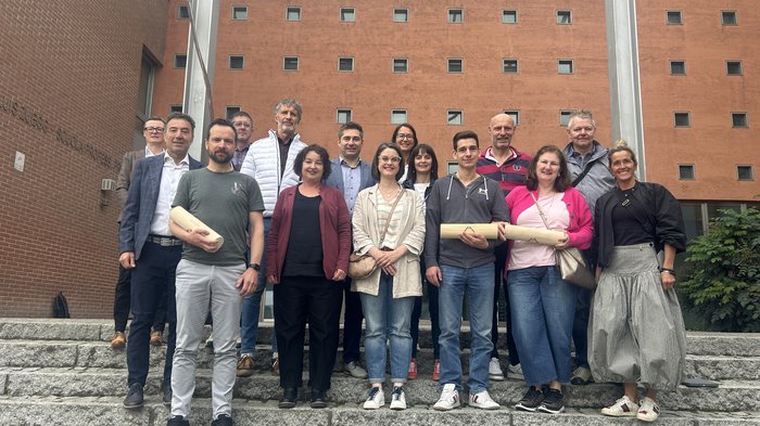 Gemeinsame Bildungsziele: lvh.apa und Berufsbildungszentrum Luis Zuegg Meran verstärken Kooperation Gruppe von 15 Personen auf einer Treppe vor rotem Gebäude