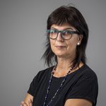 Das lvh-Team Porträt einer Frau mit dunkler Brille und Halskette vor neutralem Hintergrund