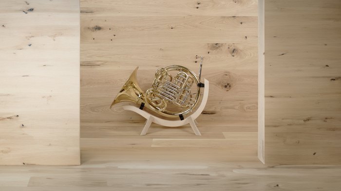 Crowdfunding-Kampagne für nachhaltige Instrumentenständer Waldhorn auf einem modernen Holzständer vor Holzwand