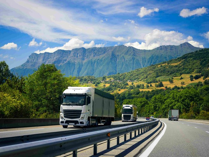 La proposta di lvh.apa: un programma di sostegno per chi vuole ottenere la patente di guida Camion che guidano su autostrada con montagne e foresta verde