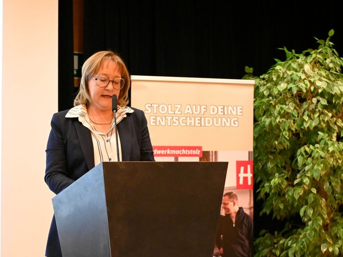 Donne alla guida del progresso Donna parla al podio davanti a un banner con scritto Orgoglioso della tua decisione