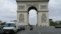 lvh-Seniorinnen und Senioren auf Frühlingsreise: Paris, mon amour! Ansicht des Arc de Triomphe mit parkenden Autos und Menschen bei bewölktem Himmel