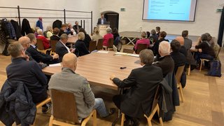 News Teilnehmer bei einem Vortrag in einem Konferenzraum mit Projektor