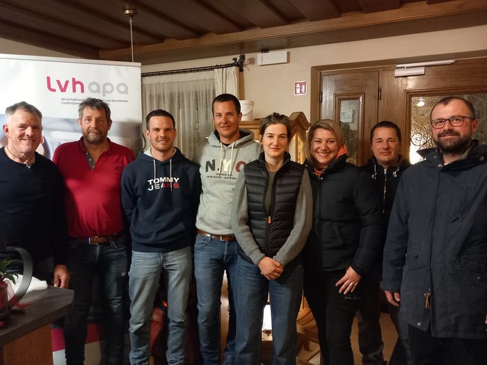 Frischer Wind im Handwerkerausschuss Gruppe von acht Personen steht gemeinsam vor einem lvhapa-Banner in einem Raum.