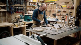 News Tischler schleift Holzstücke in einer Werkstatt mit verschiedenen Werkzeugen