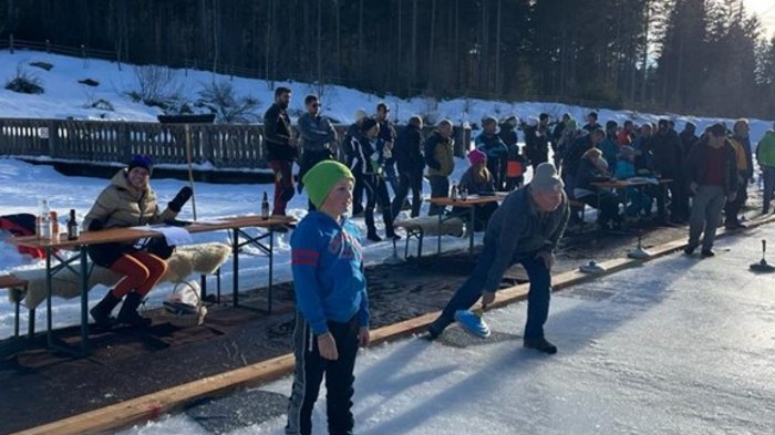Lattlschießen der Handwerker/innen erfreut sich größter Beliebtheit Menschen spielen Eisstockschießen auf zugefrorenem Gewässer im Winter
