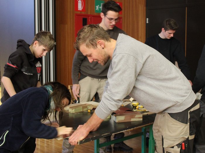 A San Genesio un’intera giornata dedicata all’artigianato Gruppo di giovani che lavorano insieme a progetti in legno in una stanza