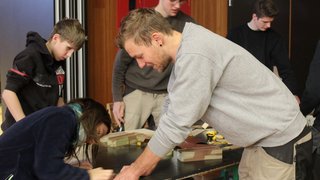 News Gruppe junger Menschen arbeitet gemeinsam an Holzprojekten in Innenraum