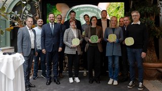 News Gruppenfoto von zwölf Personen bei einer Auszeichnung mit nachhaltigen Zertifikatstafeln