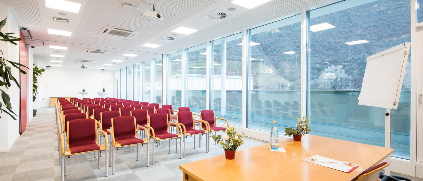 Affitto aule seminari Sala conferenze moderna vuota con sedie rosse e ampie finestre