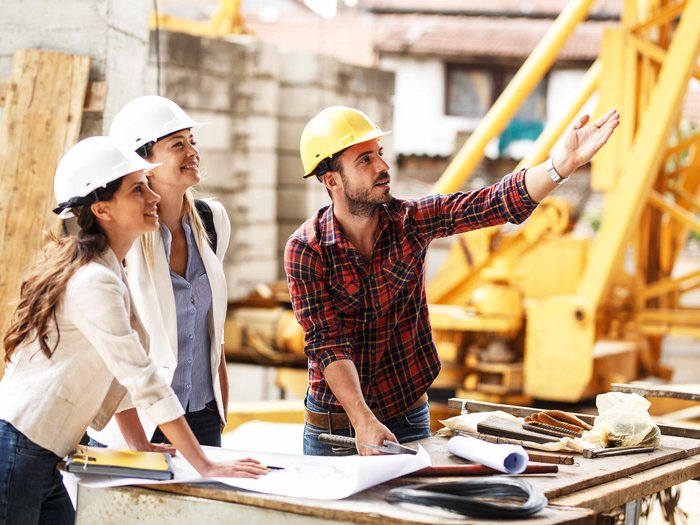 Stellungnahme zur AFI-Umfrage: Soziale Unterstützung am Arbeitsplatz Ingenieure mit Schutzhelmen besprechen Baupläne auf einer Baustelle