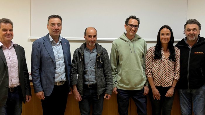 Neuer Ortsobmann für Tirol Sechs Personen stehen nebeneinander vor einer Wand in einem Innenraum