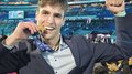 Successo altoatesino alle WorldSkills 2024 di Lione Giovane uomo a evento sportivo morde medaglia d'oro e alza il braccio per festeggiare
