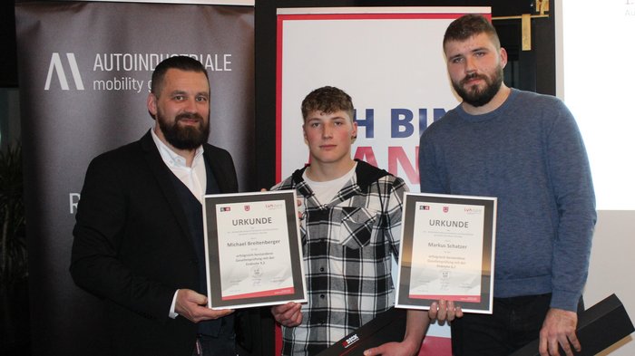 I macellai di lvh.apa guardano con soddisfazione ai successi del 2023 Tre uomini tengono certificati durante una cerimonia di premiazione con striscioni dietro