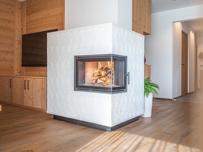 Il 20 ottobre è la Giornata della stufa in maiolica Camino moderno con piastrelle bianche in un soggiorno
