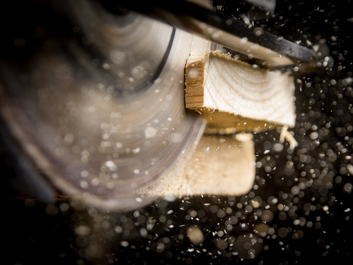 Ausbildung Drehende Kreissäge schneidet Holz mit Holzspänen im Flug