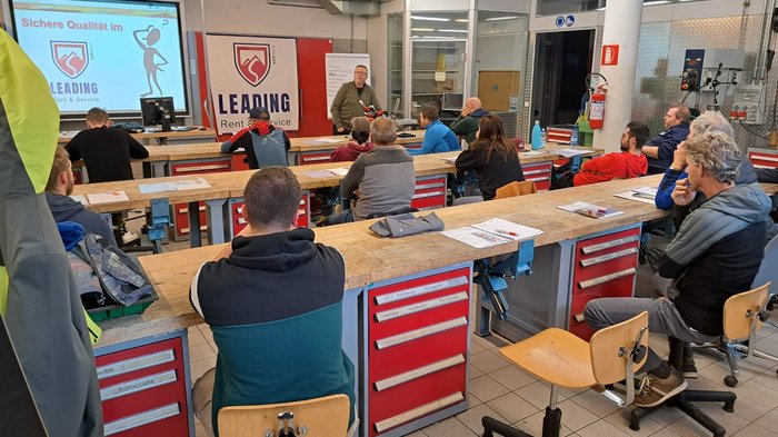 I tecnici per la manutenzione di articoli sportivi si preparano alla stagione sciistica Partecipanti in aula che ascoltano una lezione sulla qualità sicura
