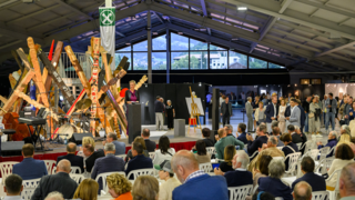 News Menschen bei einer Veranstaltung in einer großen Halle mit Kunstinstallationen