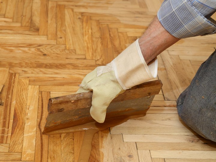 Percorso formativo Mano con guanto applica parquet in legno con spatola