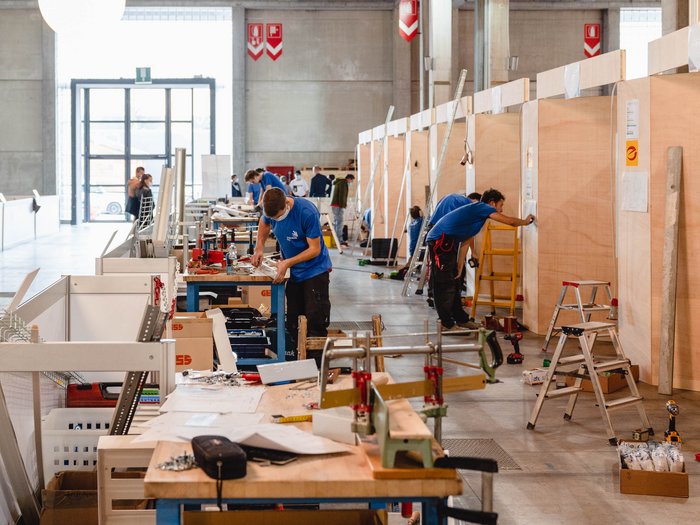 WorldSkills Italy: 115 Teilnehmer stellen sich ersten Wettbewerbsaufgaben Innenaufnahme einer Werkstatt mit Arbeitern und Werkzeugen an Holzwänden