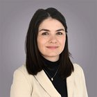 Förderungen und Finanzierungen Porträt einer Frau mit schwarzen Haaren, beiger Jacke und schwarzem Rollkragenpullover