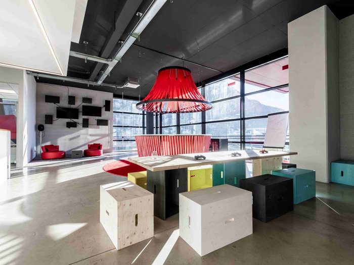 BigSEE Design Award: Südtiroler Projekte holen vier Preise Moderner Besprechungsraum mit bunten Sitzwürfeln und rotem Lampenschirm