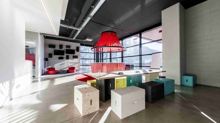 BigSEE Design Award: Südtiroler Projekte holen vier Preise Moderner Besprechungsraum mit bunten Sitzwürfeln und rotem Lampenschirm