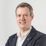 Bozen Land Porträt eines lächelnden Mannes in Anzugjacke vor weißem Hintergrund