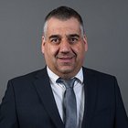 Mietwagen- und Taxiunternehmer Porträt eines Mannes in Anzug und Krawatte vor grauem Hintergrund