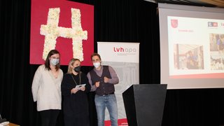 News Drei Personen mit Masken stehen vor einem lvh apa Banner und einer Leinwand