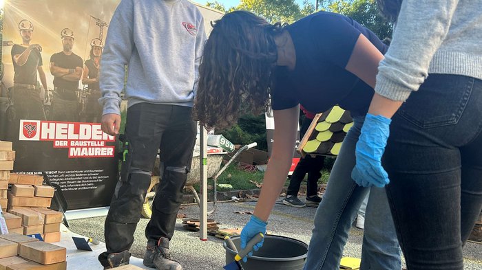 SkillsDay in Lana: Schüler/innen erleben Handwerk hautnah Jugendliche mauern zusammen einen Ziegelbau bei sonnigem Wetter
