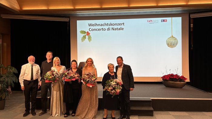 Note di festa: il Concerto di Natale 2024 di lvh.apa Gruppo di persone con fiori sul palco durante il concerto di Natale