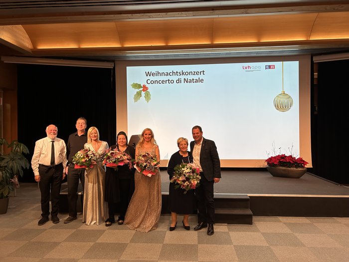 Feierliche Klänge: Das lvh-Weihnachtskonzert 2024 Gruppe von Menschen mit Blumen auf der Bühne beim Weihnachtskonzert