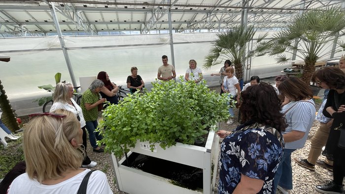 Spunti innovativi per le artigiane dell'Alta Val Pusteria Gruppo di persone intorno a pianta in serra durante visita guidata