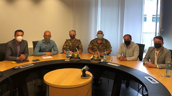 Militärabgänger als potentielle Fachkräfte im Handwerk Sechs Männer mit Masken an einem runden Konferenztisch in einem Büro