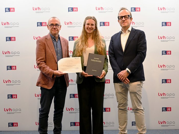 lvh vergibt Stipendium Drei Personen posieren mit Urkunden vor lvhapa-Logo-Wand