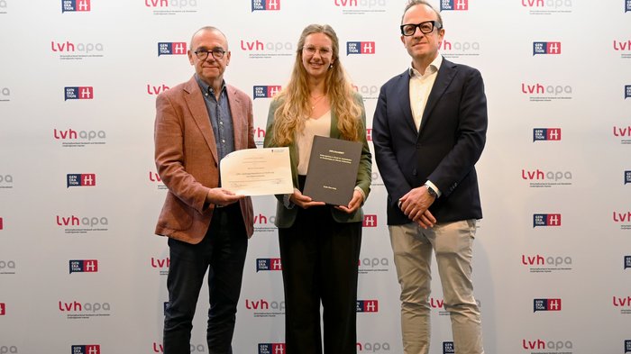 Borse di studio di lvh.apa Tre persone posano con diplomi davanti allo sfondo del logo lvhapa