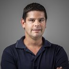 Consulenza fiscale, contabilità e calcolo della busta paga Primo piano di un uomo con polo blu scuro su sfondo grigio