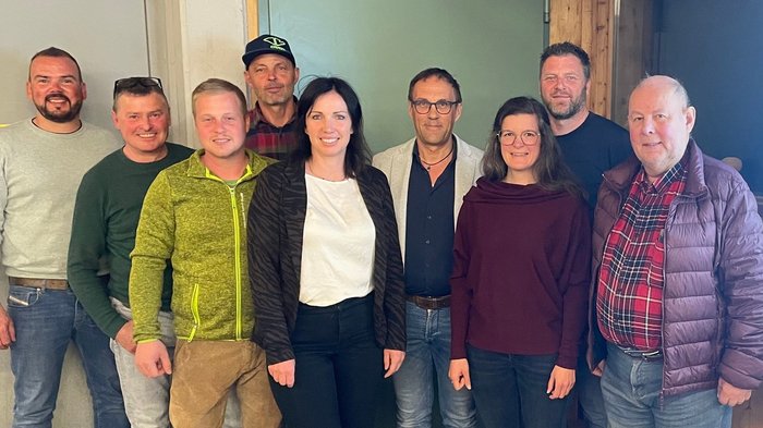 Handwerk mit Herz und Handschlagqualität: lvh-Ortsversammlung St. Lorenzen wird zum Fest der Verbundenheit Gruppenfoto von neun Erwachsenen in lässiger Kleidung vor einer Wand