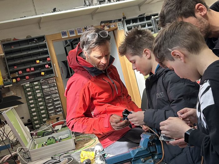Handwerk zum Anfassen: SkillsDay begeistert im Oberpustertal Mann erklärt zwei Jungen technische Bauteile in Werkstatt
