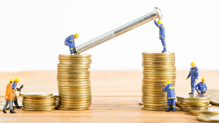 Hohe Zinsen bedrohen Unternehmen: lvh fordert Aktivierung des Rotationsfonds Miniaturarbeiter montieren große Schraube auf Stapel goldener Münzen