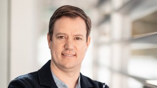 Martin Haller © Florian Andergassen Porträt eines lächelnden Mannes in Business-Kleidung mit verschränkten Armen