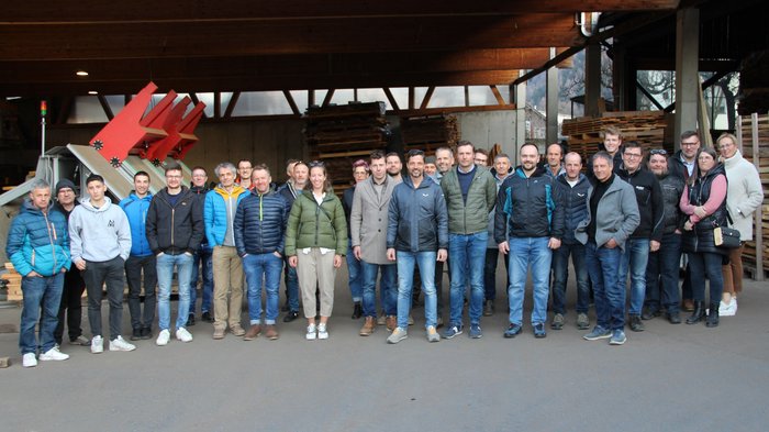 Jahresversammlung der Sägewerker/innen und Verpackungshersteller/innen: Weichenstellung für die Zukunft der Holzbranche Gruppenfoto von 28 Personen in einer Holzlagerhalle