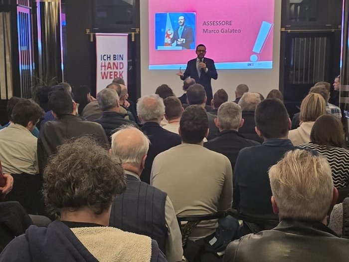 Macellai a confronto: formazione, macelli e prospettive future Uomo che tiene una presentazione davanti a un pubblico con diapositiva sullo sfondo