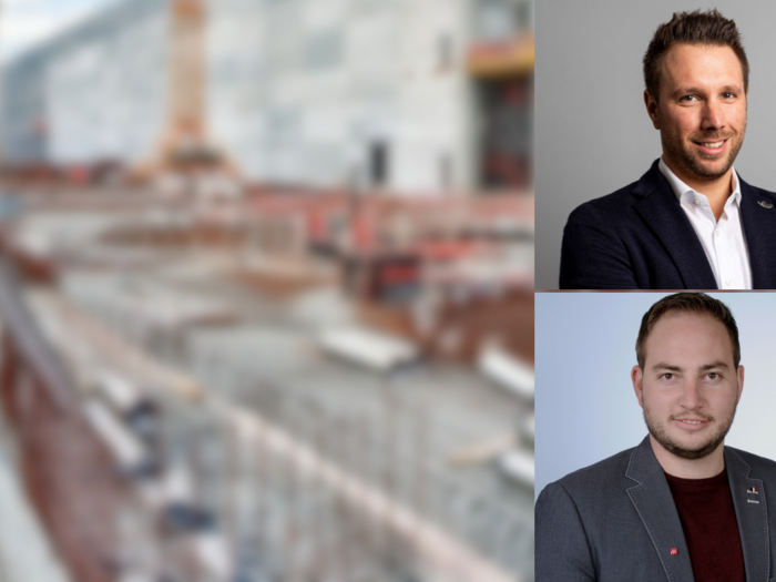 Wichtige Investitionen in Mörtel und Asphalt Zwei Geschäftsleute vor unscharfem Baustellenhintergrund