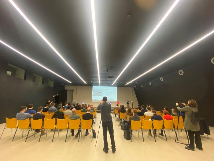 Der techParcour: Zukunft ist jetzt Menschen in gelben Stühlen sehen eine Präsentation in modernem Konferenzraum