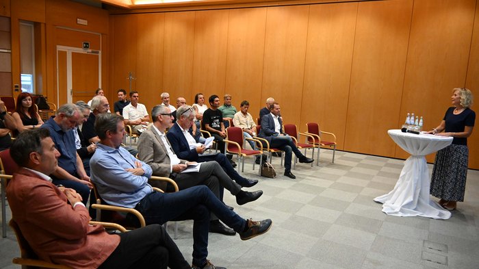 Mitreden. Mitgestalten. Mitbestimmen – lvh stärkt Austausch mit Südtirols Gemeinden Frau hält Vortrag vor sitzendem Publikum in einem Konferenzraum