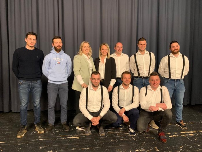 Neuer Ortsausschuss der Handwerker/innen gewählt Gruppe von zehn Personen in legerer und formeller Kleidung vor einem Vorhang